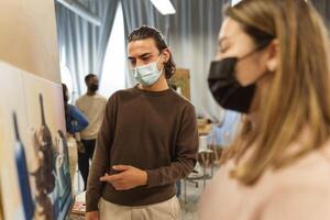 jung Studenten tragen Gesicht Maske während Lektion im Fakultät von Kunst Universität - - Lernen und Kultur Konzept foto