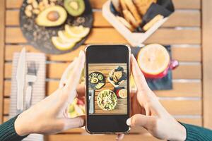 oben Aussicht weiblich Hände nehmen Foto mit Handy, Mobiltelefon Smartphone auf Heide Mittagessen Essen - - jung Mädchen haben Spaß mit Neu Technologie Apps zum Sozial Medien - - Menschen gesund Lebensstil und Technik süchtig Konzept