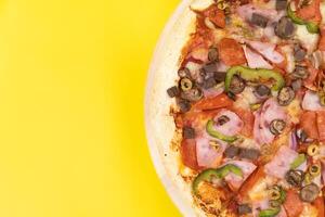 köstlich groß Pizza mit Kalbfleisch und Pilze auf ein Gelb Hintergrund foto