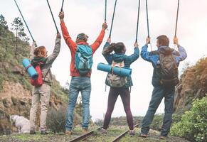 Gruppe von freunde erziehen Hände oben halten Trekking Stangen auf ein Gipfel von Berg - - jung Menschen erkunden das Natur - - Konzept von Wanderung, Reise und Bergsteigen foto