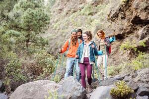 glücklich Mannschaft freunde tun Trekking Ausflug auf Berge - - Gruppe jung Touristen Wandern und erkunden das wild Natur - - Wanderer, Wanderung Sport und Reise Menschen Konzept foto