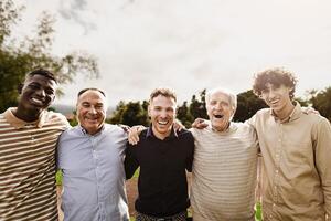 glücklich Mehrgenerationenhaus Gruppe von Männer mit anders Alter und Ethnien haben Spaß lächelnd im Vorderseite von Kamera beim Park foto