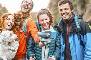 Gruppe freunde filmen Video mit kardanisch Handy, Mobiltelefon Smartphone während Trekking Berg - - glücklich jung Menschen haben Spaß mit Neu Technologie während Wanderung Ausflug - - Reise und Technik Jugend Kultur Konzept foto