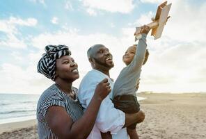 glücklich afrikanisch Familie haben Spaß auf das Strand während Sommer- Ferien - - Eltern Liebe und Einheit Konzept foto