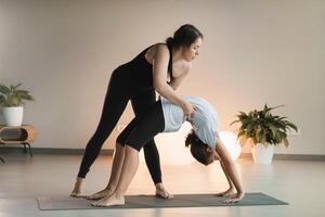 Mama und Teenager Tochter tun Gymnastik zusammen im das Fitness Zimmer. ein Frau und ein Mädchen Zug im das Fitnessstudio foto