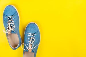 Blau Schuhe Stand auf ein isoliert Gelb Hintergrund foto