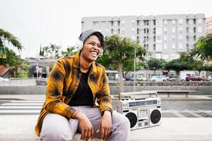 glücklich afrikanisch Frau haben Spaß Hören zu Musik- mit Kopfhörer und Jahrgang Boombox Stereo foto