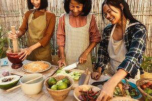 glücklich Süd-Ost asiatisch Familie haben Spaß vorbereiten thailändisch Essen Rezept zusammen beim Haus Terrasse foto