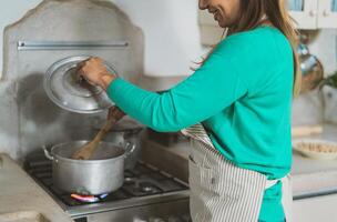 Latein reifen Frau Kochen im alt Jahrgang Küche - - lächelnd Mutter vorbereiten starten beim Zuhause foto