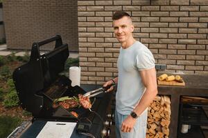 ein Mann auf das Straße ist Kochen ein Steak auf das Grill beim ein Grill foto