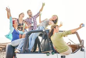 Gruppe von glücklich freunde nehmen Selfie mit Handy, Mobiltelefon Clever Telefon auf Cabrio Auto - - jung Menschen haben Spaß Herstellung Party während ihr Straße Ausflug - - Freundschaft, Urlaub, Jugend Ferien Lebensstil Konzept foto
