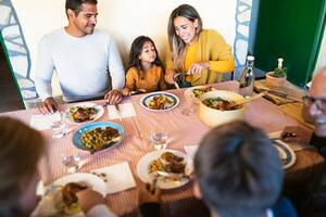 glücklich Latein Familie haben Spaß Mittagessen zusammen beim Zuhause foto