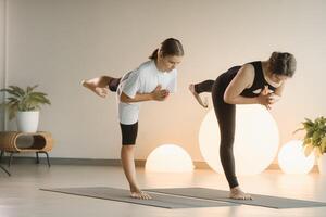 Mama und Teenager Tochter tun Gymnastik zusammen im das Fitness Zimmer. ein Frau und ein Mädchen Zug im das Fitnessstudio foto