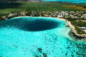 oben Aussicht von das Blau Bucht Lagune von Mauritius. ein Boot schwimmt auf ein Türkis Lagune foto