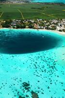 oben Aussicht von das Blau Bucht Lagune von Mauritius. ein Boot schwimmt auf ein Türkis Lagune foto