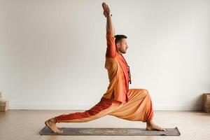 ein Mann im ein Orange passen tut Yoga im ein Fitness Zimmer. das Konzept von Gesundheit foto