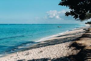 Aussicht von das Weiß Strand und Türkis Ozean mit ein festgemacht Motor- Boot aus das Küste von Mauritius foto