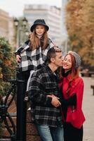 ein stilvoll Familie von drei Spaziergänge durch das Herbst Stadt posieren zum ein Fotograf . Papa, Mama und Tochter im das Herbst Stadt foto