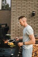 ein Mann auf das Straße ist Kochen ein Steak auf das Grill beim ein Grill foto