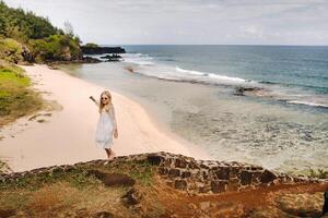 ein Mädchen im ein Weiß Kleid auf das gris-gris Strand auf das Insel von Mauritius foto