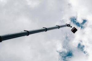 angehoben hoch im das Himmel Wiege von ein Auto Kran. das höchste LKW Kran mit ein Gelb Wiege zum lösen Komplex Aufgaben foto