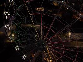 schön Sonnenuntergang Über das Stadt mit ein beleuchtet Ferris Rad. foto