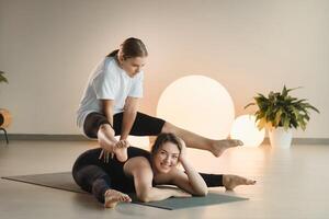 Mama und Teenager Tochter tun Gymnastik zusammen im das Fitness Zimmer. ein Frau und ein Mädchen Zug im das Fitnessstudio foto