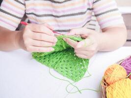 Nahansicht von Frau Hand Stricken mit Grün wolle foto