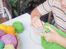 Nahansicht von Frau Hand Stricken mit Grün wolle foto