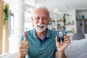 Blut Zucker testen beim heim. Überprüfung Blut Zucker Niveau beim heim. Diabetiker Überprüfung Blut Zucker Ebenen. Senior Mann Überprüfung Blut Zucker Niveau durch Glukometer und Prüfung Streifen beim Zuhause foto