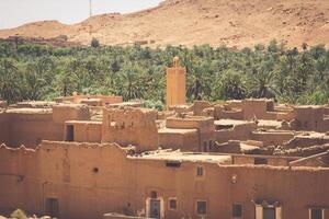 ein Dorf beim ein Oase beim das Unterseite von ein Schlucht im das Atlas Berge, Marokko foto