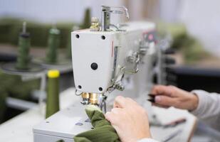 Arbeitskräfte im ein industriell Kleidungsstück Fabrik nähen Kleider auf Nähen Maschine foto