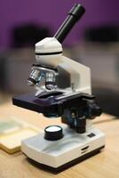 Fachmann Mikroskop im ein Schule Labor zum das Studie von Zellen und Bakterien foto