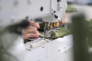 Arbeitskräfte im ein industriell Kleidungsstück Fabrik nähen Kleider auf Nähen Maschine foto