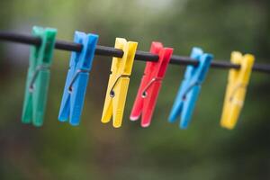 anders Farben von Wäscheklammern zum gewaschen Kleider auf ein Zeichenfolge foto