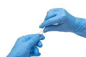 medizinisch behandschuhte Hand halten Spritze mit ein Korn von Flüssigkeit entstehenden testen das Funktion von das Spritze foto