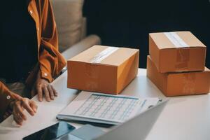 Geschäftsfrau Start klein Geschäft und erfolgreich sme Unternehmer asiatisch Frau hoding Kisten funktioniert von Zuhause liefern Pakete online. sme Lieferung Konzept und Verpackung foto