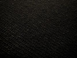 Hintergrund von gestrickt Textur von schwarz Farbe Stoff oder Strickwaren Nahaufnahme. Kopieren Raum foto