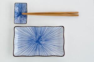 ein Landschaft Bild von ein Blau Keramik Sushi Teller einstellen mit hölzern Essstäbchen. foto