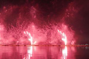 ein bunt Feuer funktioniert während ein Feier im das Fluss mit schön Betrachtung im das Wasser foto