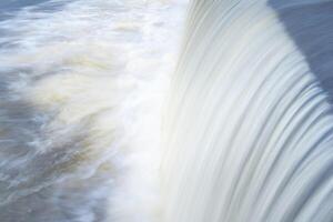 ein rein Weiß Wasserfall Hintergrund gebildet im das Fluss durch ein prüfen Damm foto