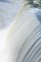 ein rein Weiß Wasserfall Hintergrund gebildet im das Fluss durch ein prüfen Damm foto