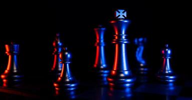 Goldener Schachkönig, der um andere Schach herum steht, das Konzept eines Anführers muss Mut und Herausforderung im Wettbewerb, Führung und Geschäftsvision haben, um in Planspielen zu gewinnen foto