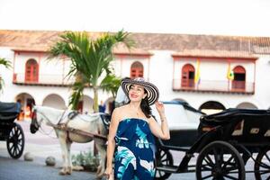 schön Frau tragen das traditionell kolumbianisch Hut namens Sombrero vueltiao beim das Zoll Platz auf das historisch Straßen von das Cartagena de Indien ummauert Stadt foto
