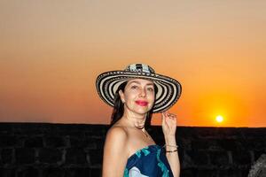 schön Frau tragen das traditionell kolumbianisch Hut namens Sombrero vueltiao beim das historisch Straßen von das Cartagena de Indien ummauert Stadt foto