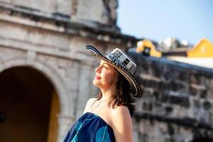 schön Frau tragen das traditionell kolumbianisch Hut namens Sombrero vueltiao beim das Frieden Platz auf das historisch Straßen von das Cartagena de Indien ummauert Stadt foto