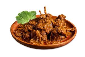 Hammelfleisch Curry oder Lamm Curry mit Grüner Salat Blätter, lassen Sie uns pata auf ein hölzern Platte, ist würzig indisch Küche. Hammelfleisch Soße ist ein köstlich indisch Curry Gericht von weich. Weiß Hintergrund isoliert foto
