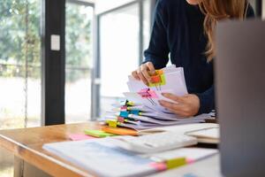 Sekretär ist suchen durch Stapel von wichtig Unterlagen auf Büro Tabelle liefern Sie zu Manager zum Präsentation im Zeit beim treffen. Konzept von Schwierigkeit finden Information von Haufen von dokumentieren foto