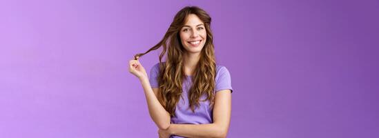 zärtlich zuversichtlich gut aussehend abgehend lockiges Haar Mädchen spielen locken berühren Strand Haar lächelnd begeistert Friseur bereiten gut aussehen Abend Datum Neigung Kopf freudig grinsend Kreuz Arm Truhe foto