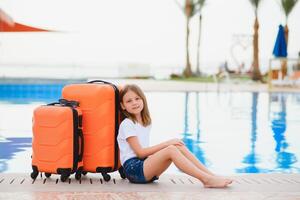 Mädchen mit Koffer durch das Schwimmbad im ein Luxus Hotel. Meer und Betrachtung, Reisen und entspannend Zeit Konzept. foto
